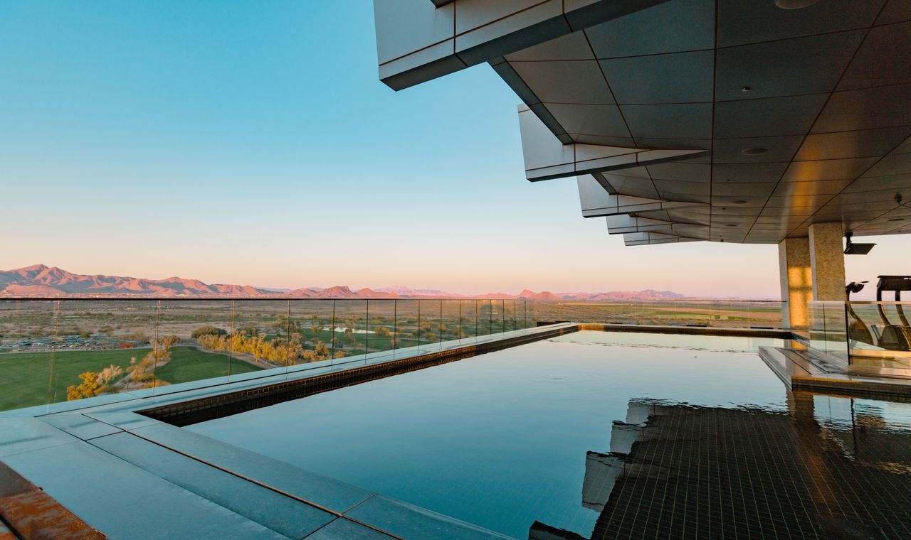 An infinity-edge resort pool looking out over Sonoran desert mountains at dusk, the luxury Scottsdale market FinTruction supports with construction bookkeeping