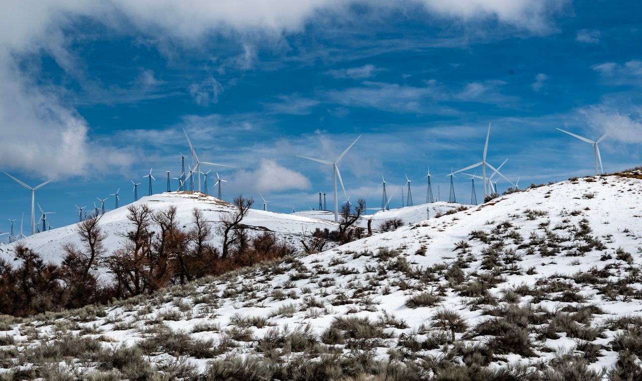 Rows of wind turbines along snow dusted ridgelines in the Tehachapi Pass, part of the Kern County energy build-out we support