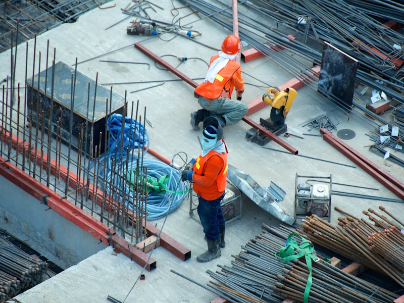 Construction workers on a high-rise job site with rebar and safety equipment