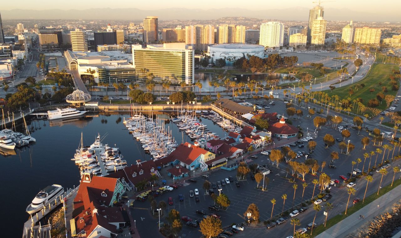 Downtown Long Beach at sunset with Shoreline Village and a tower crane over a high-rise under construction, the work FinTruction tracks with job costing