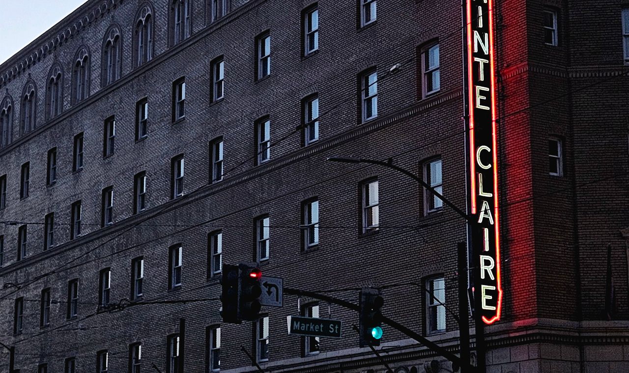 Neon Sainte Claire sign on a brick hotel facade at Market Street, downtown San Jose, where we code contractor job costs
