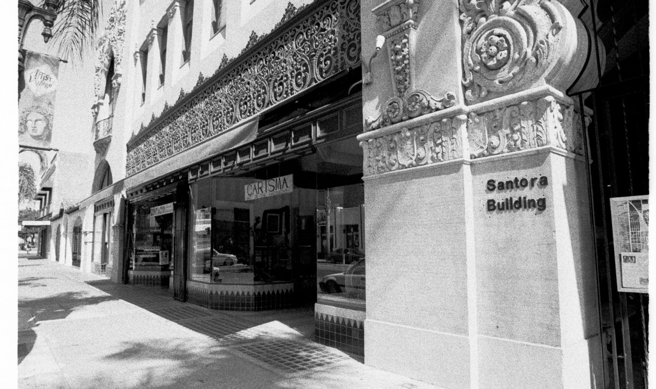 Ornate carved facade and Santora Building sign on a downtown Santa Ana sidewalk, the historic core its trade contractors renovate