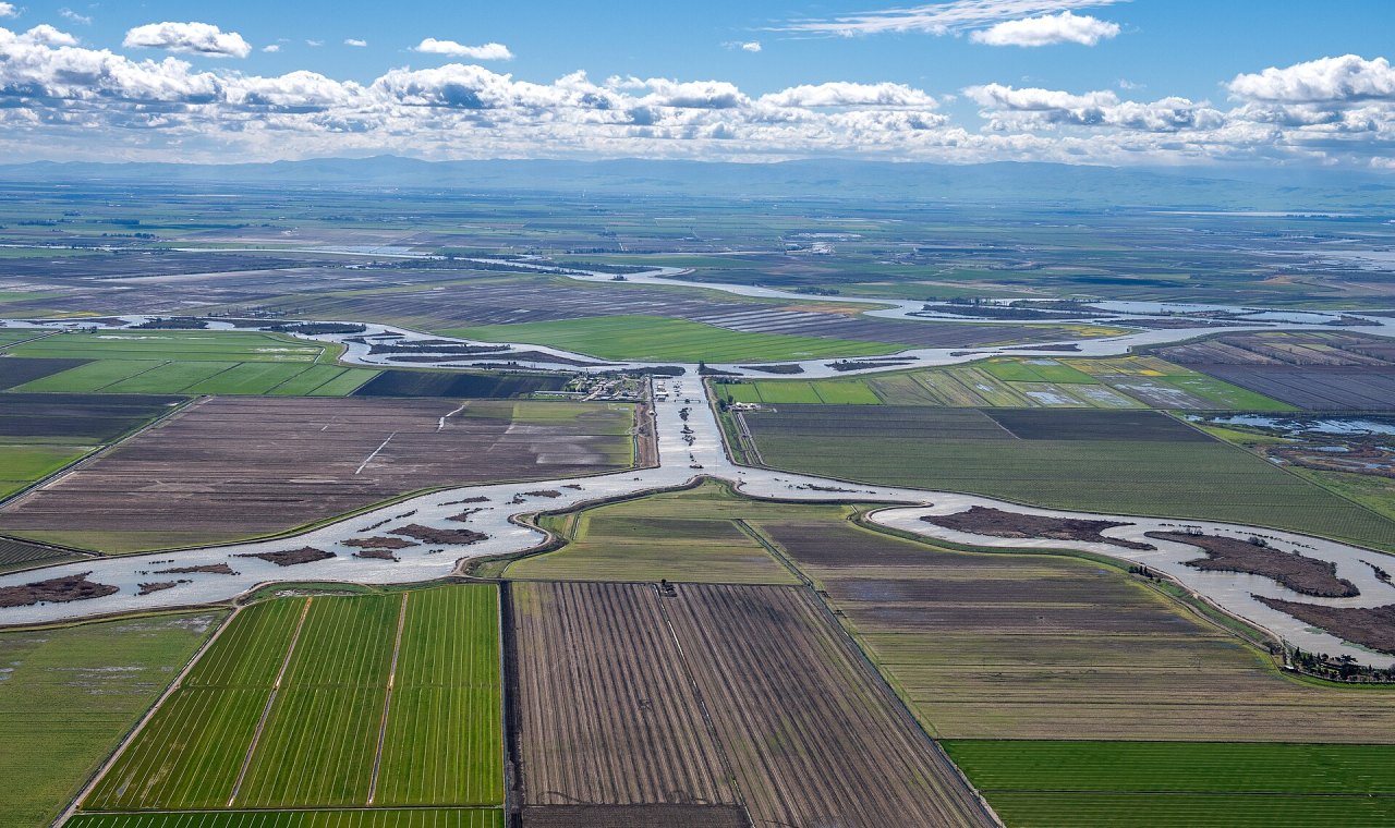 Aerial view over leveed Delta farmland and sloughs in San Joaquin County, the flood control and water infrastructure market we support with job costing