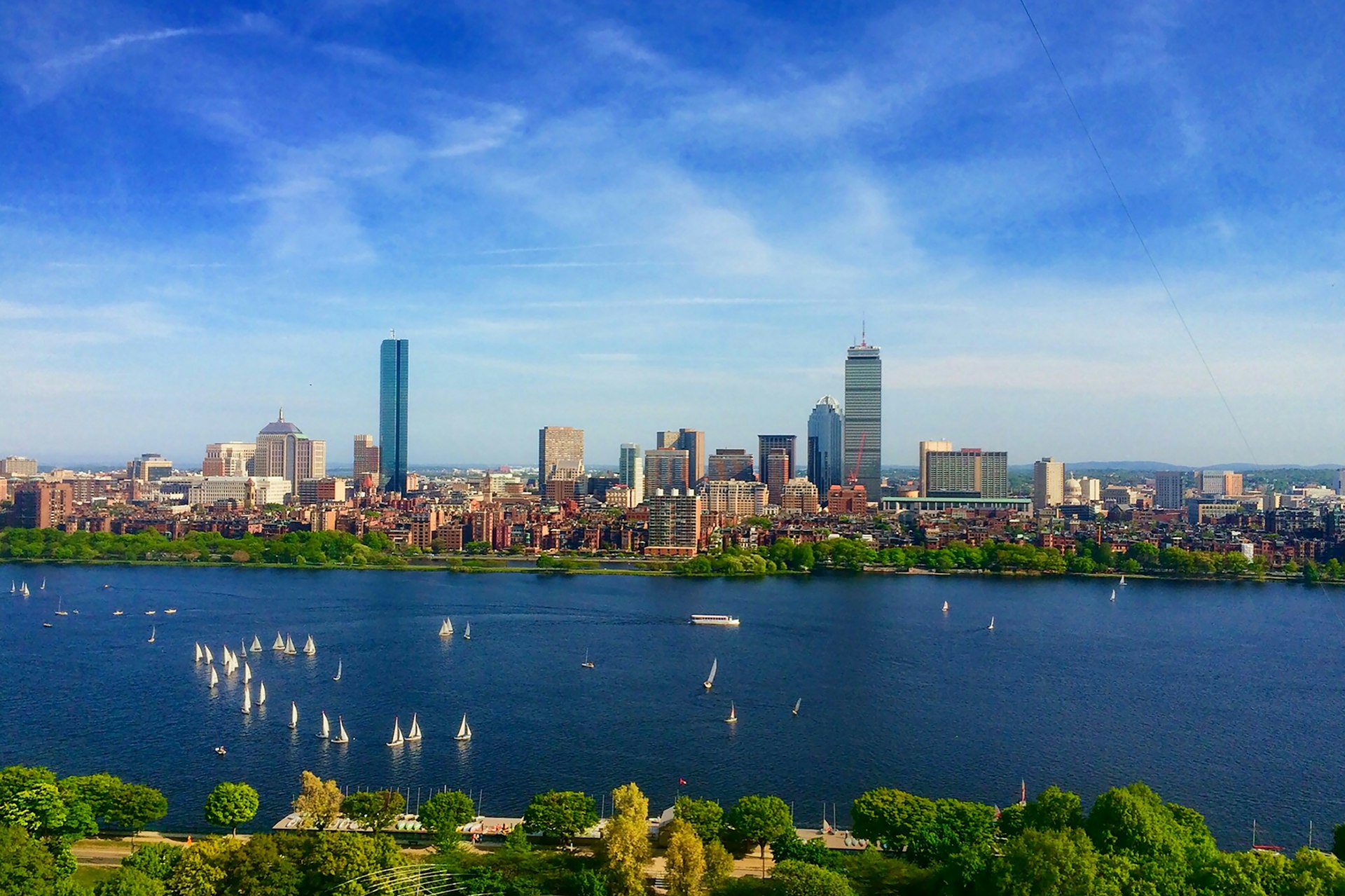Boston skyline and Back Bay seen across the Charles River with sailboats out, the Massachusetts market FinTruction serves with construction accounting