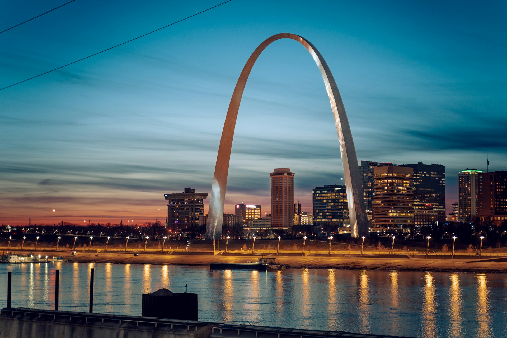 The Gateway Arch at dusk over the Mississippi River, downtown St. Louis behind it, a Missouri market FinTruction serves with construction accounting