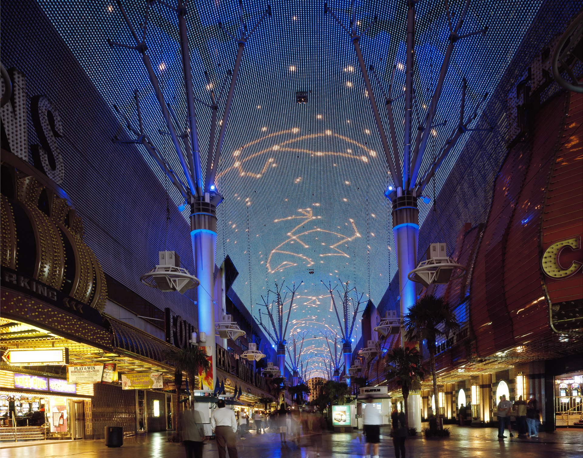 The lit LED barrel canopy over the Fremont Street Experience in downtown Las Vegas at night, neon casino signs and pedestrians below
