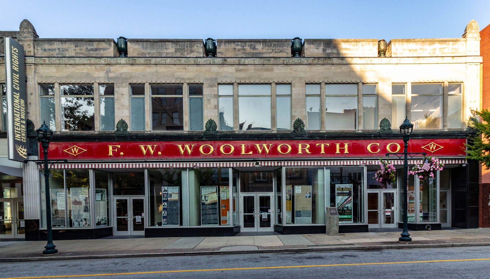 The restored F. W. Woolworth storefront on South Elm Street in downtown Greensboro, now the International Civil Rights Center and Museum, red sign and striped awnings in early light