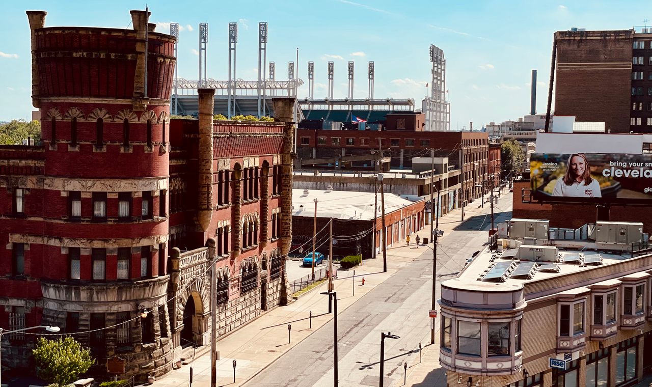 Cleveland Grays Armory in red brick with ballpark light towers behind it, part of the older building stock local rehab contractors work on