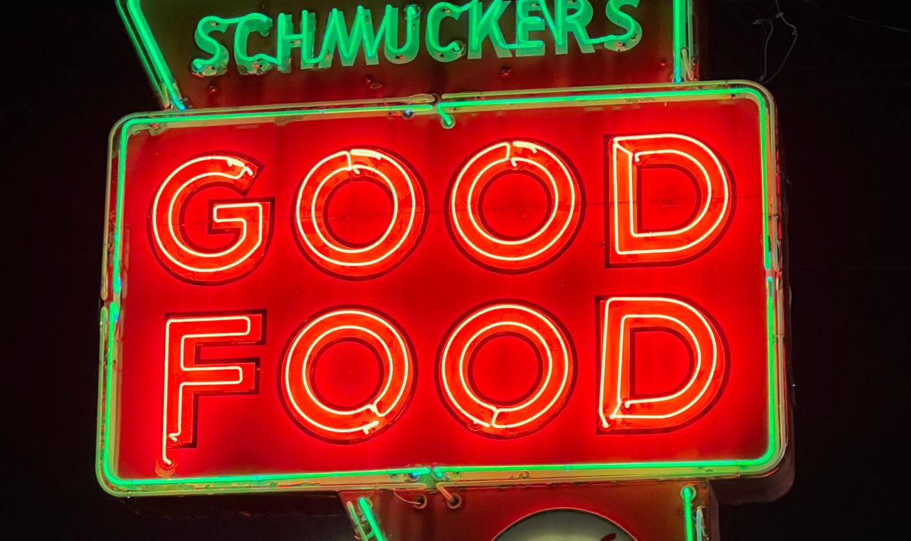 Schmucker's neon Good Food sign glowing red and green at night in Toledo, the Ohio market FinTruction serves