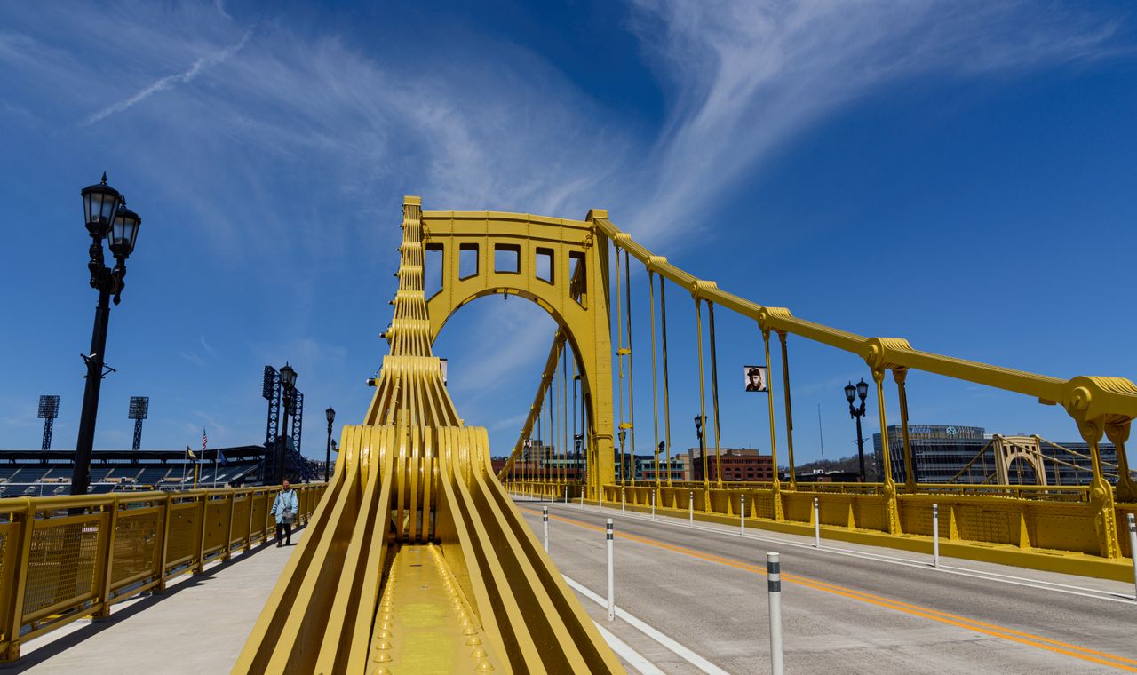 Yellow steel suspension bridge deck over the Allegheny River in Pittsburgh, the market FinTruction serves with construction bookkeeping