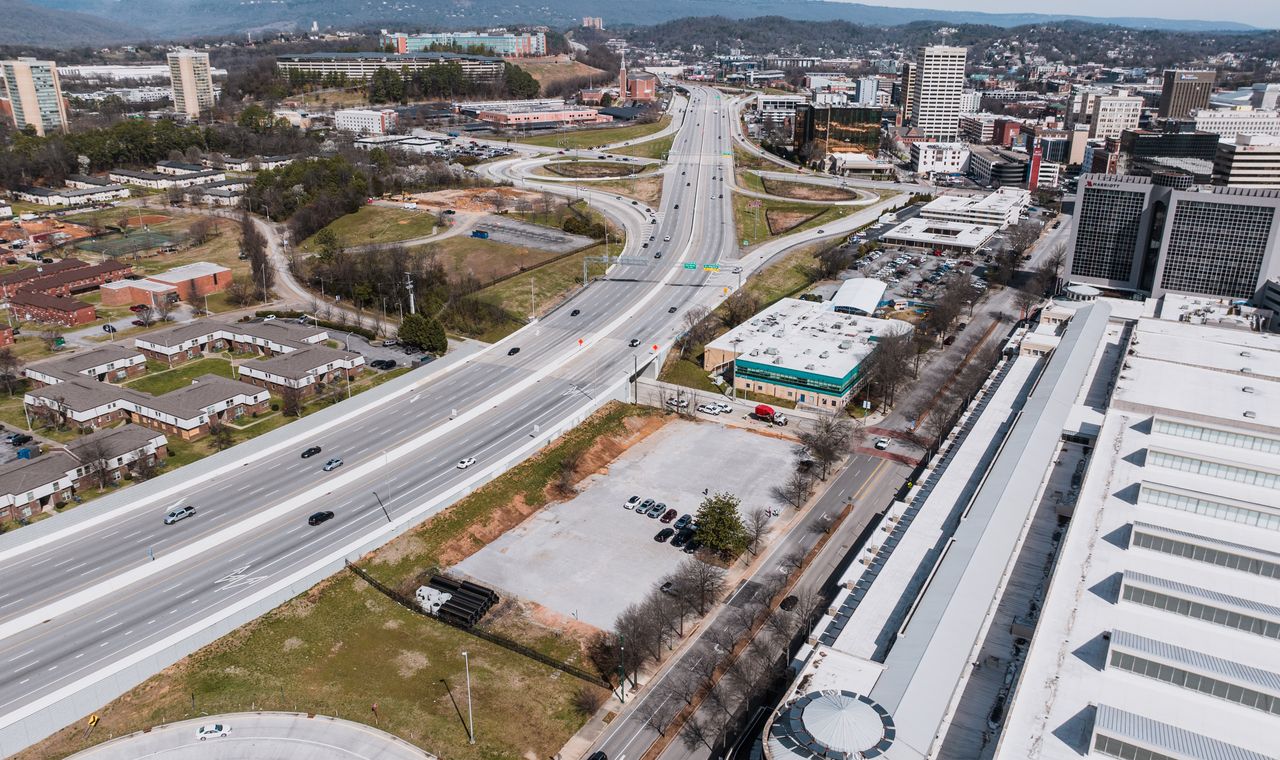 Aerial view of the interstate corridor cutting past downtown Chattanooga office towers, the logistics crossroads FinTruction supports with contractor bookkeeping