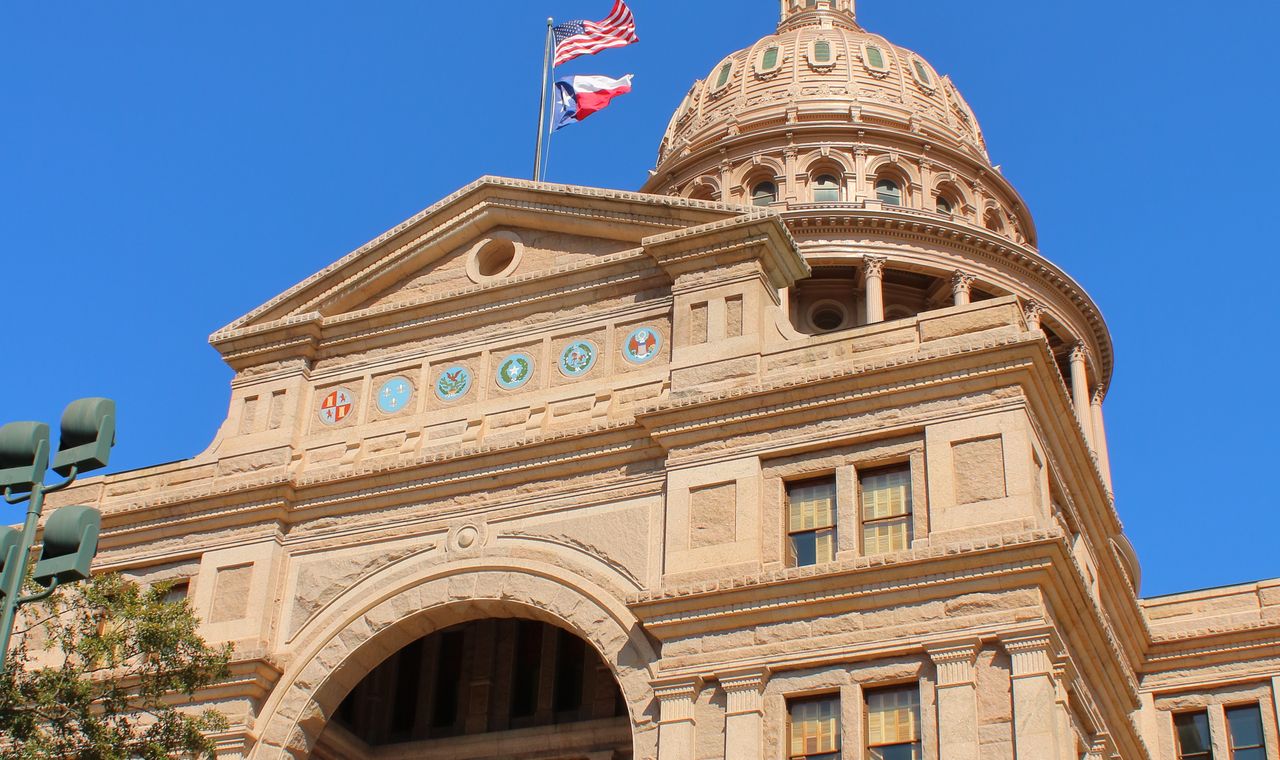 Texas State Capitol dome and flags in Austin, the Central Texas market FinTruction serves with construction bookkeeping
