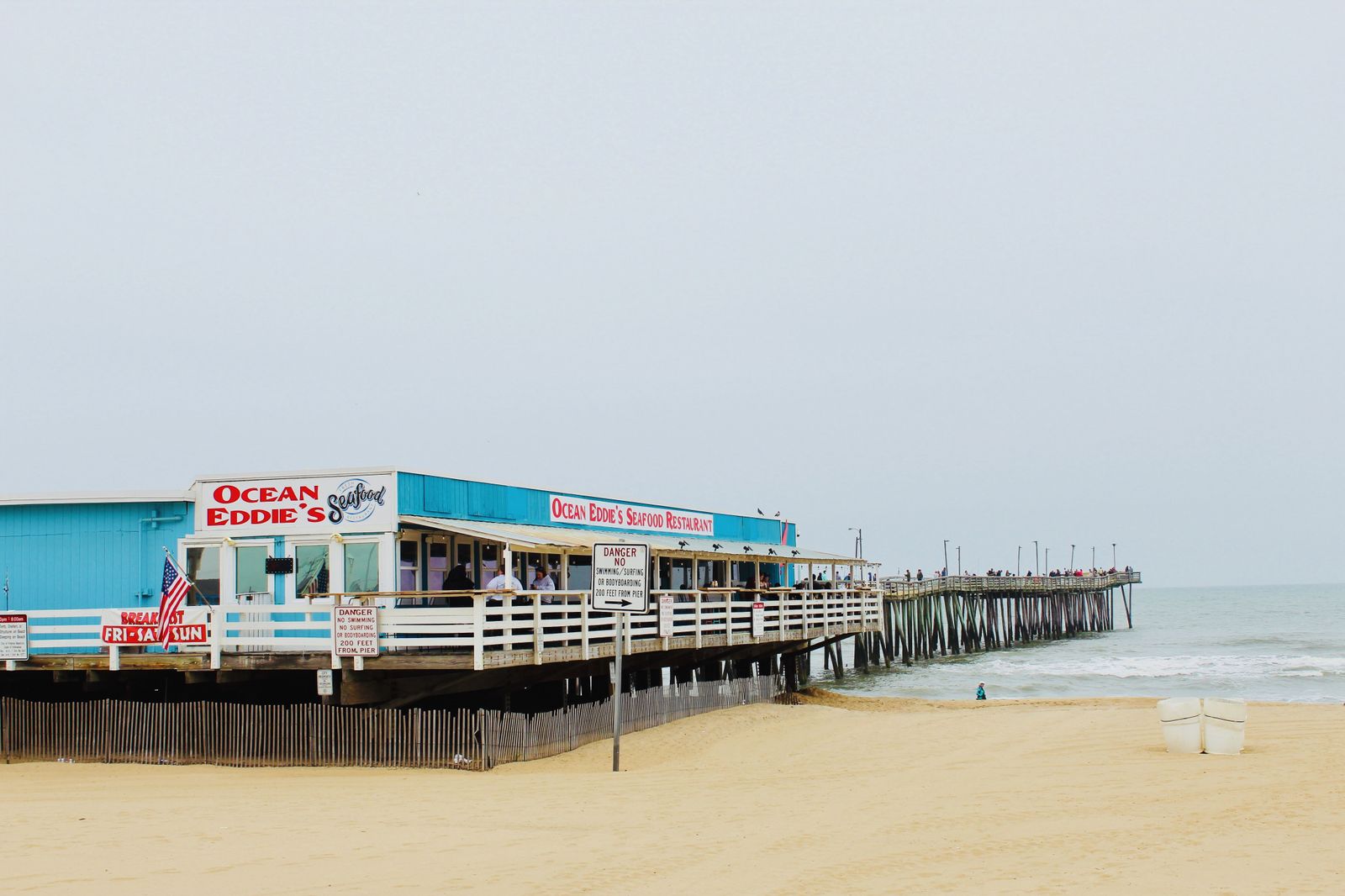 Ocean Eddie's Seafood Restaurant on the Virginia Beach fishing pier, the timber pier running out over the Atlantic beyond a wide stretch of sand